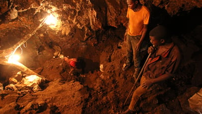 Mwinilunga, Zambia - December 6th, 2012: Three young African miners work in an underground mine and dig for resources