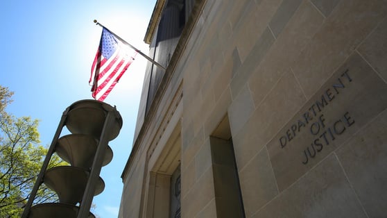US Department of Justice building and the American flag under the sun