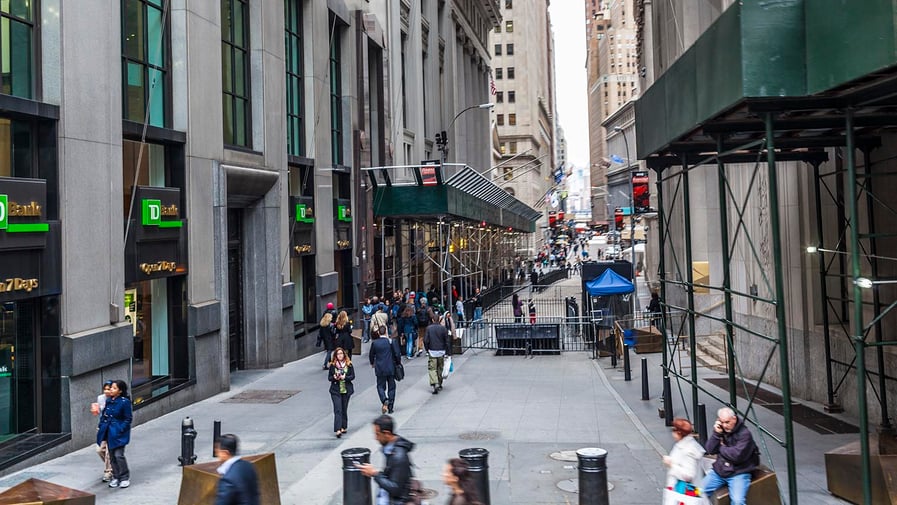 People can be seen on both sides of Wall Street. On the left, the TD Bank.